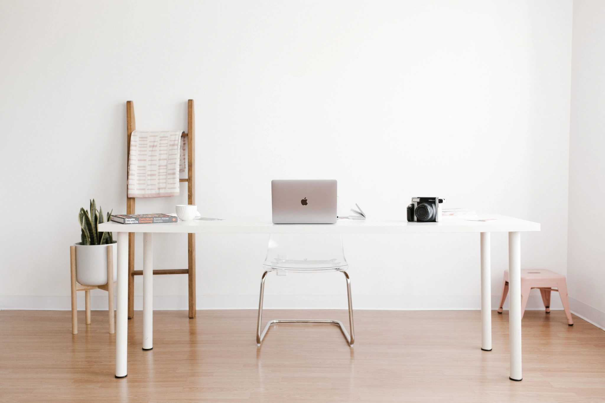 Heller Arbeitsplatz mit einem MacBook auf einem weißen Tisch